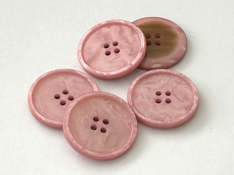 Marmorierter Kunststoffknopf in Rosa mit vier Löchern und erhabenem Rand