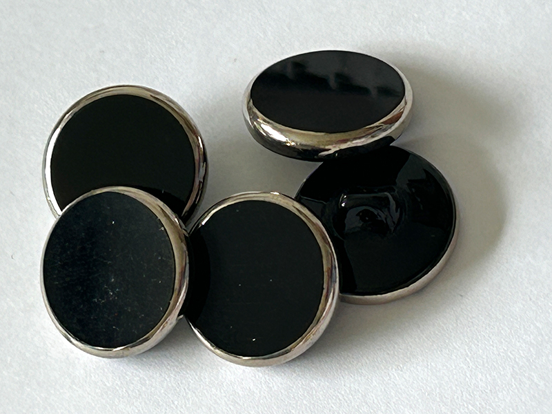 Schwarze Glasknöpfe mit silbernem Rahmen und eingearbeiteter Öse