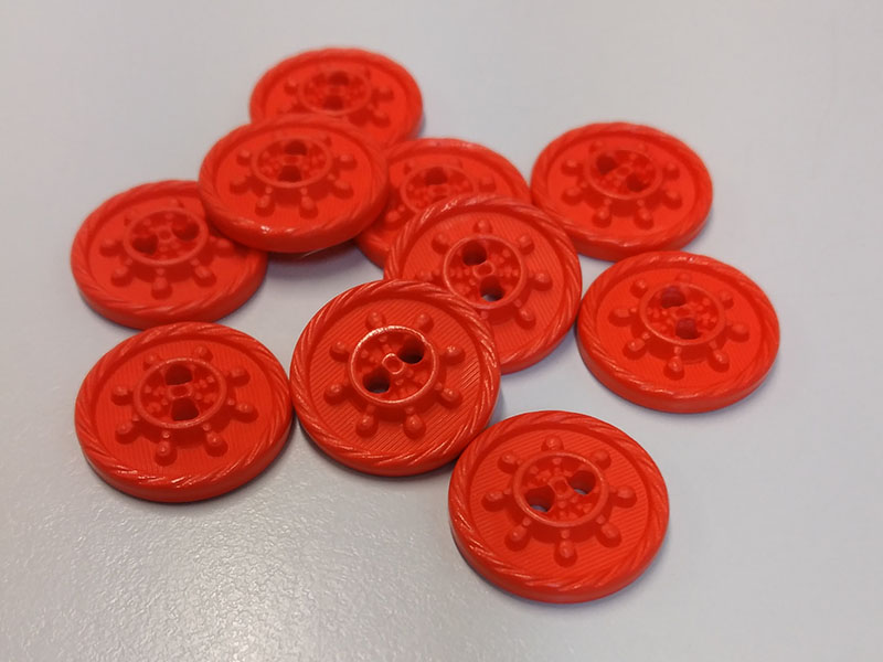 Neon-orange-rote Kunststoffknöpfe mit Steuerrad-Motiv