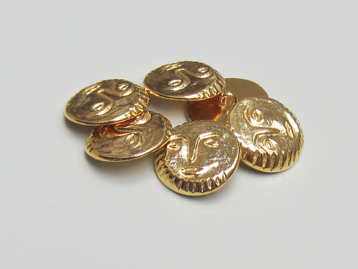 Glänzend goldfarbener Metallknopf mit Gesicht