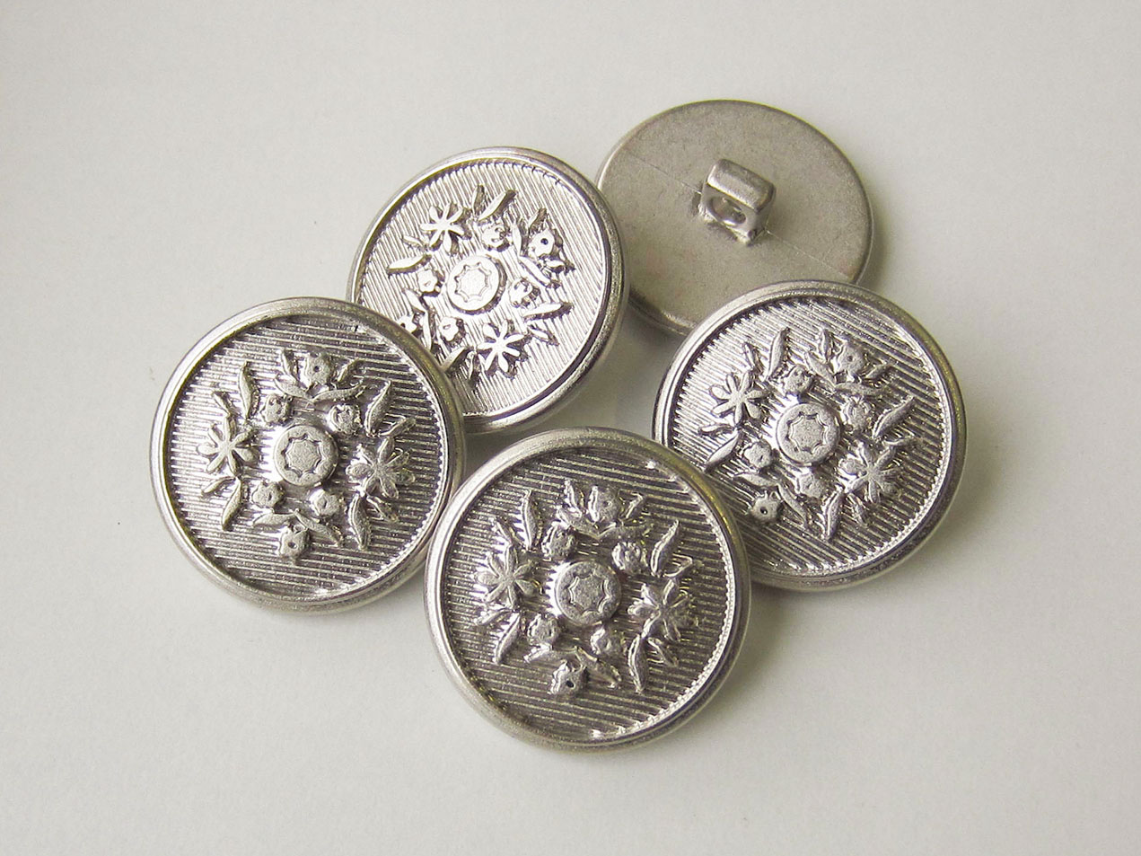 Schraffierter Knopf in Metall Optik mit Blumen Muster