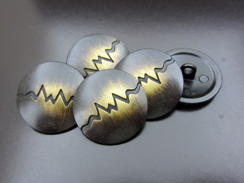 Altmessingfarbener Metallknopf mit Kurve