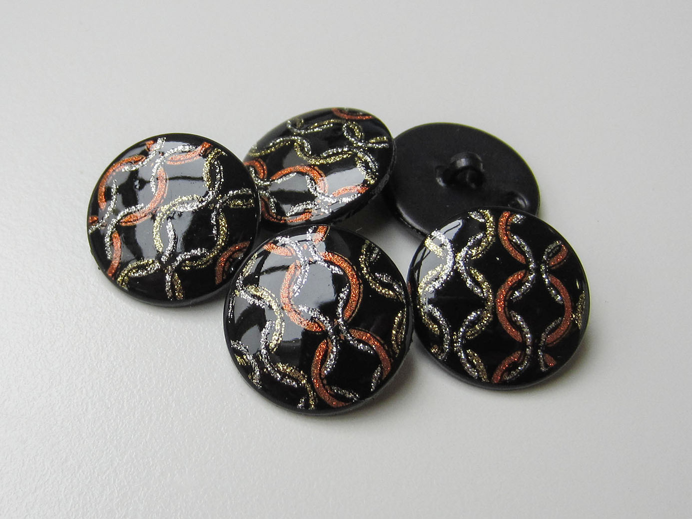 Schwarzer Knopf mit Tricolor Metallic Ketten Design