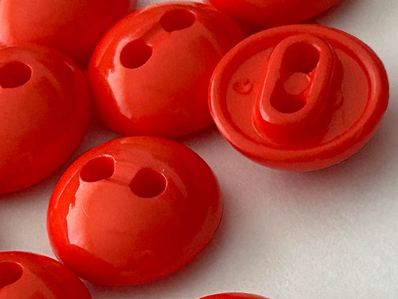 Kleine Blusenknöpfe in Orange mit halbkugelförmiger Form