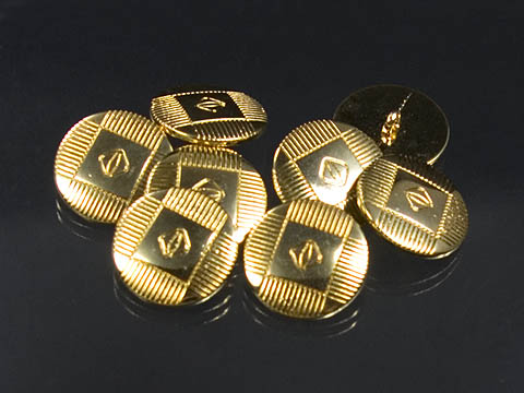 Goldener Metallknopf mit abstraktem Muster