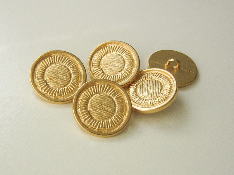 Metallknopf in Gold mit schraffiertem Muster
