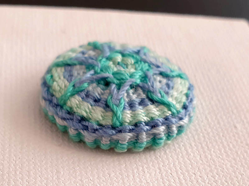 Handgemachter Posamentenknopf, handmade, blau-grüne Farbvariation, gewebt, gestickt