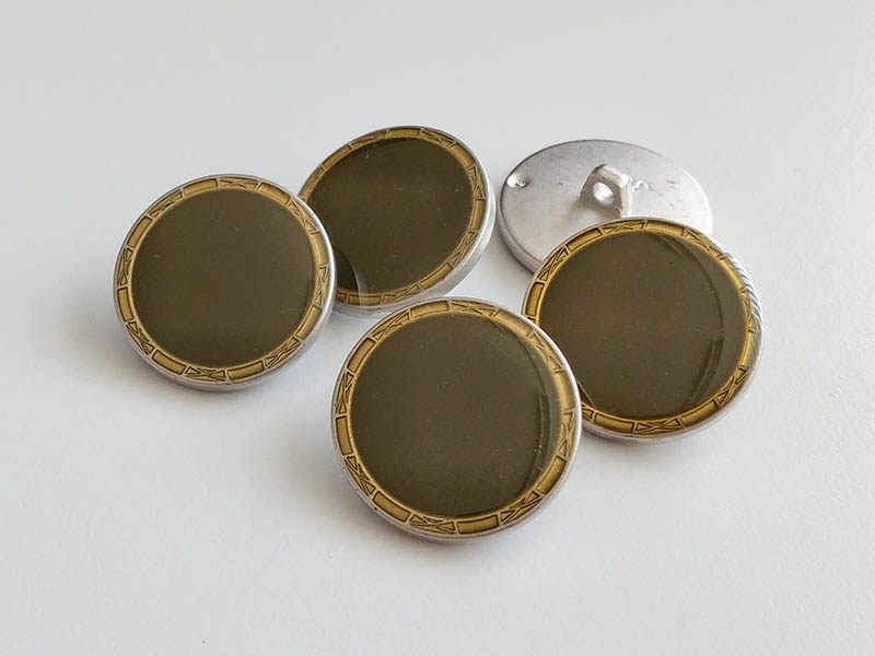 Glänzend olivgrüner Ösenknopf mit altgoldfb.  Einfassun