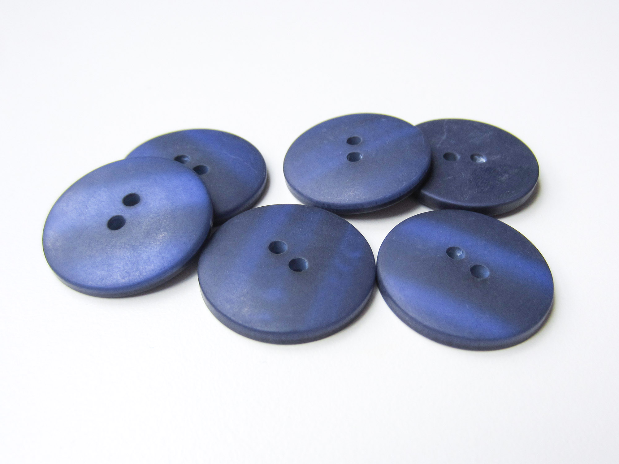Faszinierender blau schimmernder Kunststoff Knopf