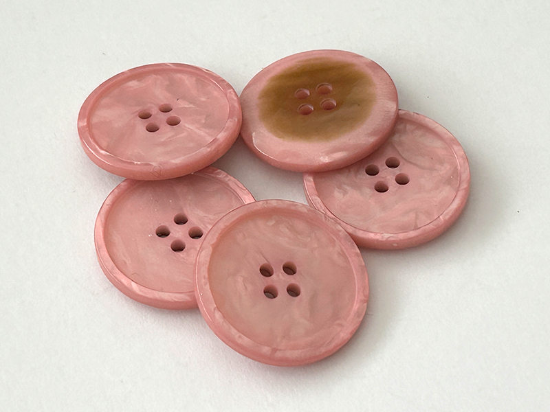Marmorierter Kunststoffknopf in Rosa mit vier Löchern und erhabenem Rand