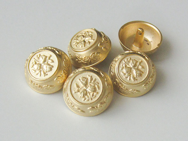 Goldfarbene Knöpfe mit Blumenmotiv