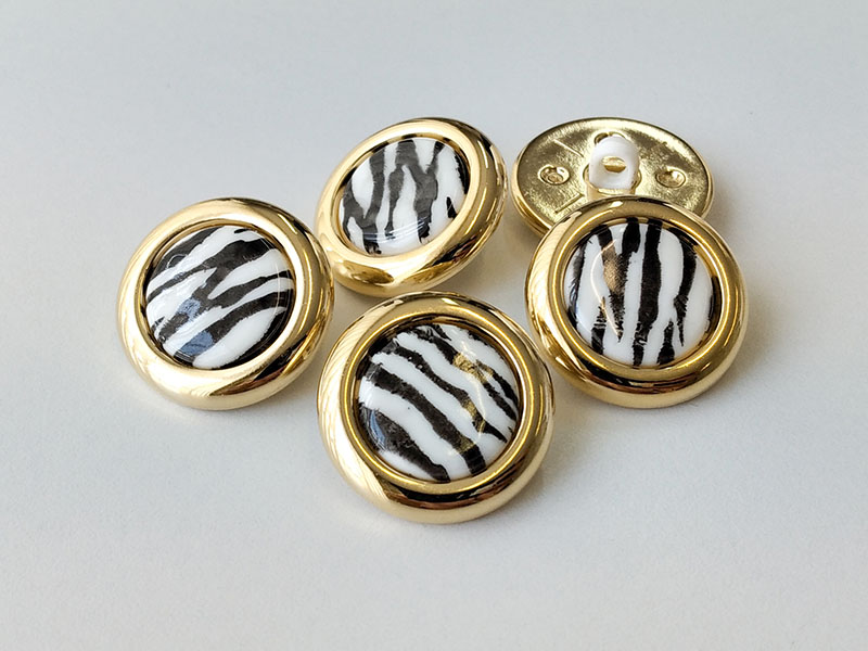 Exklusive Kunststoffknöpfe im Zebra Design mit goldfb. Rand