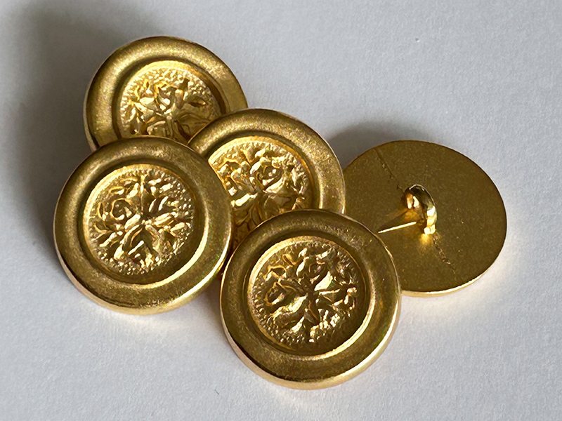 Matt goldene Metallknöpfe mit organischem Relief und Öse