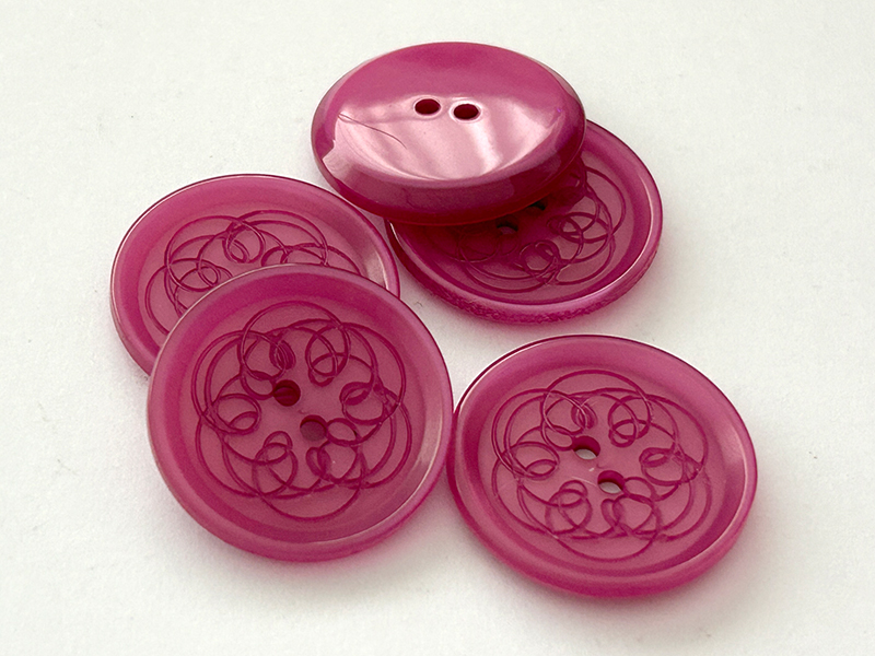 Transparente Kunststoffknöpfe in Pink-Magenta mit Ornamentmuster