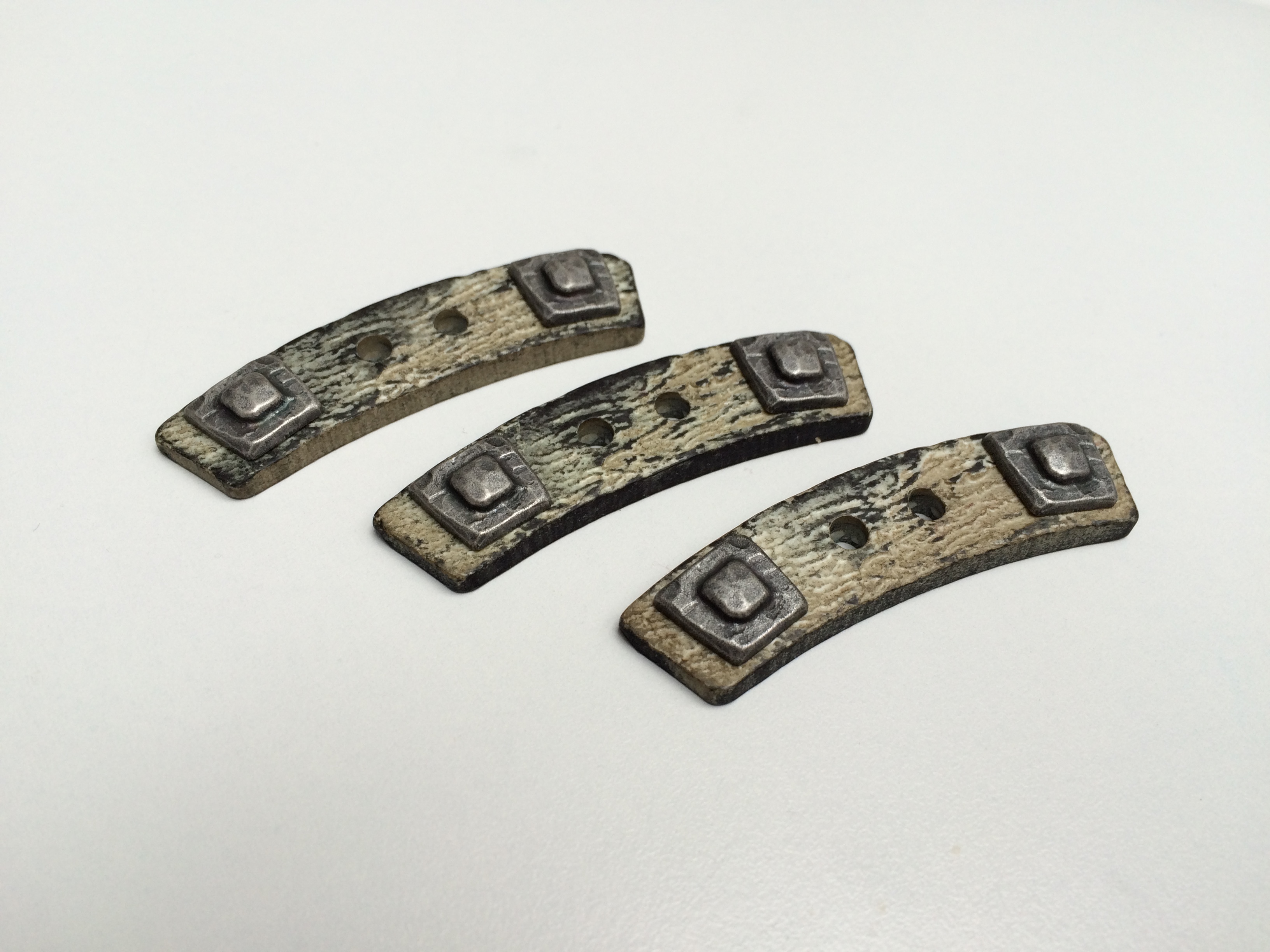 Urige gebogene Knebelknöpfe aus Kunststoff mit viereckiger Applikation in Metall Optik