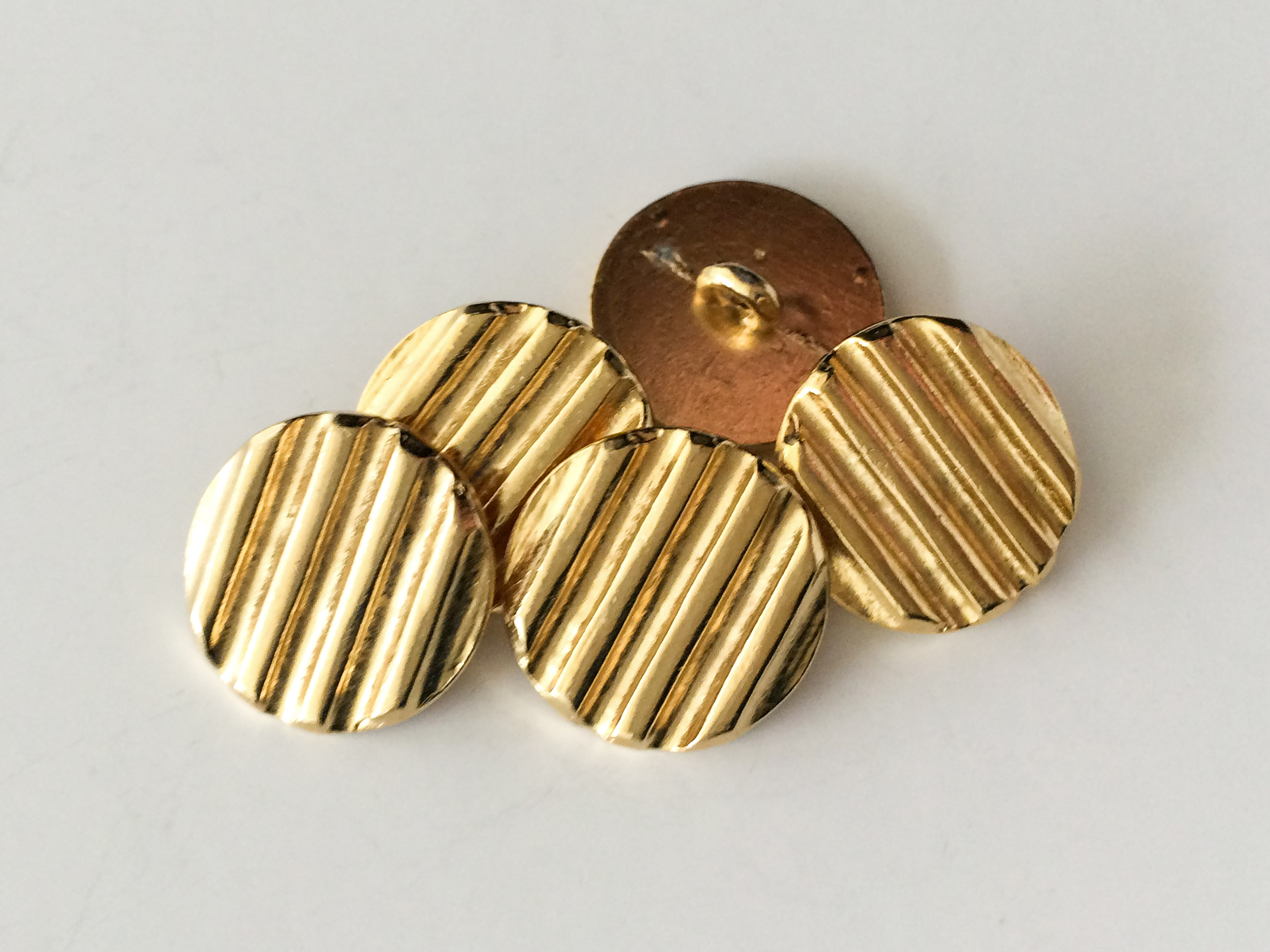 Stark gerillte goldfarbene Metallknöpfe