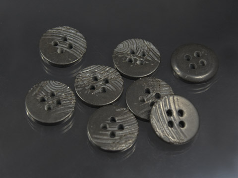 Schwarz braun schraffierter Knopf wie Naturmaterial