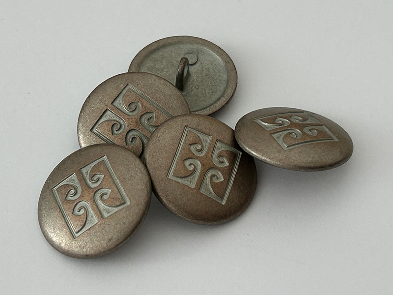 Metallknopf dunkel silber-kupferfarben mit ornamentalem Muster