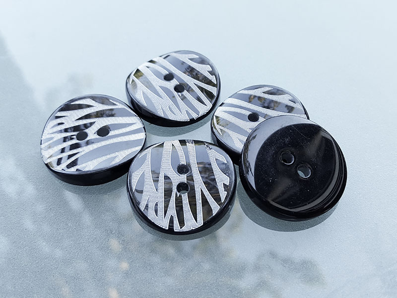Schwarzer Mantel Knopf in Zebra Optik mit zwei Knopflöchern