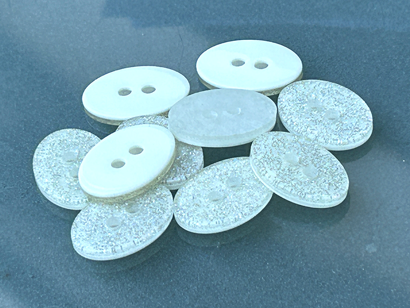 Weiße Glitzerknöpfe aus Kunststoff – kleine Funkelstücke