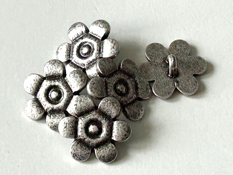 Altsilberfarbene Metallknöpfe in außergewöhnlicher Form einer Blüte