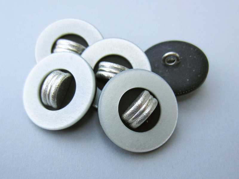Silbergrau schwarzer Knopf mit silberfarb. Applikation