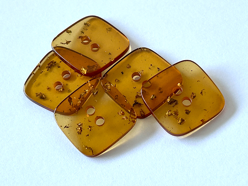 Quadratischer Knopf in transparenter Bernstein-Optik mit Blattgold-Effekten – 2-Loch