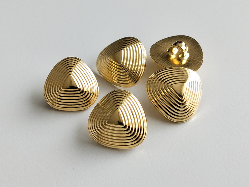 Leichte, goldfarbene Kunststoffknöpfe in interessanter Form