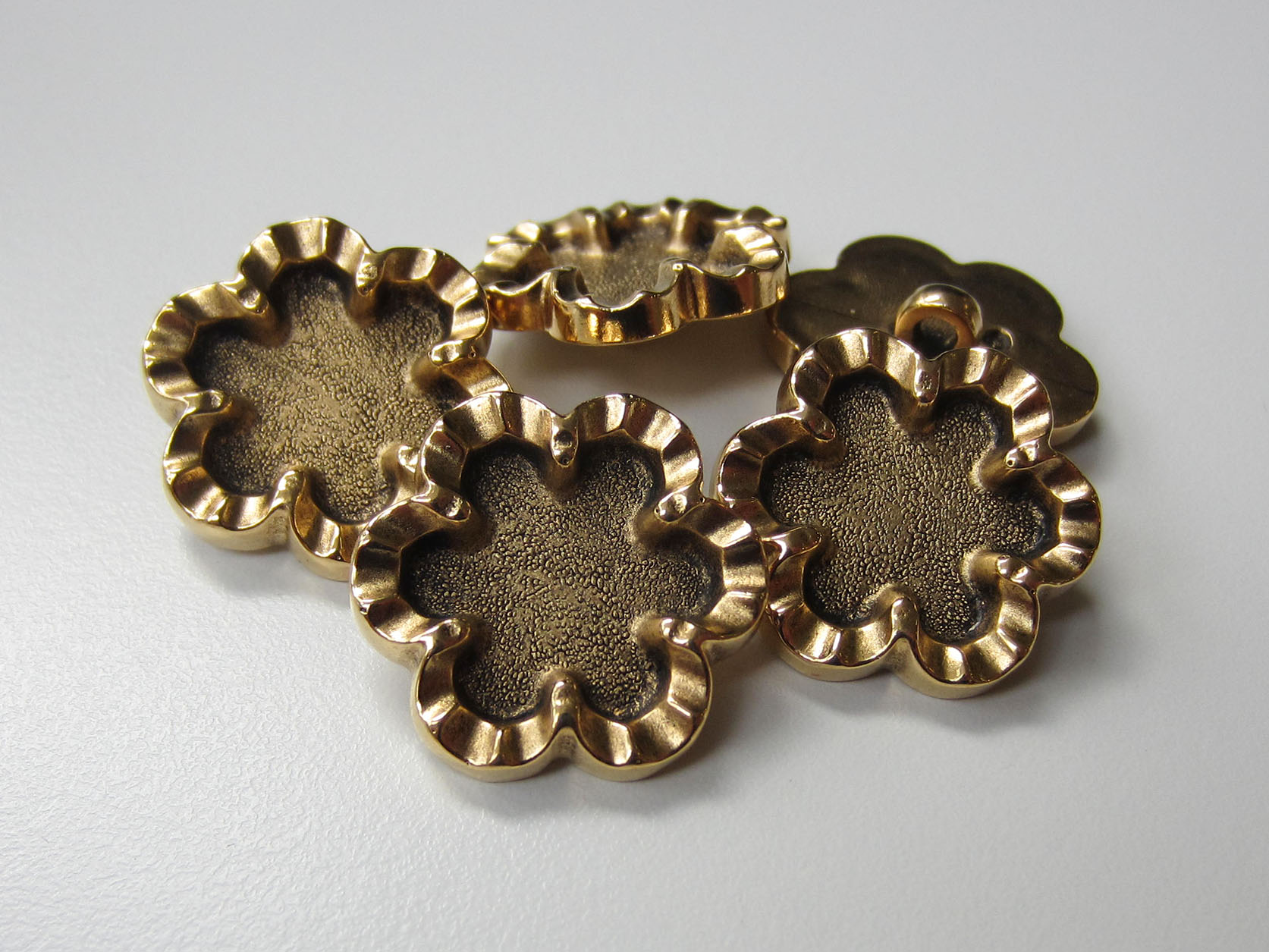 Altgoldfb. Kunststoff Knopf in abstrakter Blumen Form