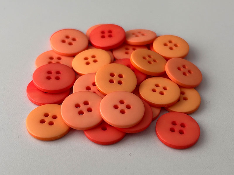Packung mit 30 rot-orange gemischte Kunststoffknöpfe