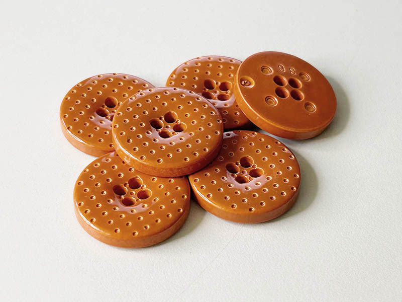 Glänzende, herbstlich orange-braune Kunststoffknöpfe