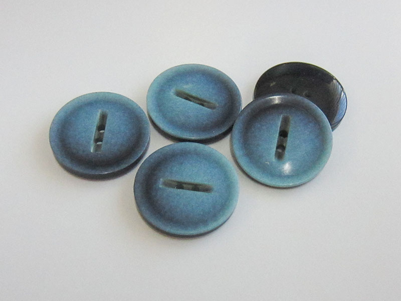 Faszinierender blau irisierender Kunststoff Knopf