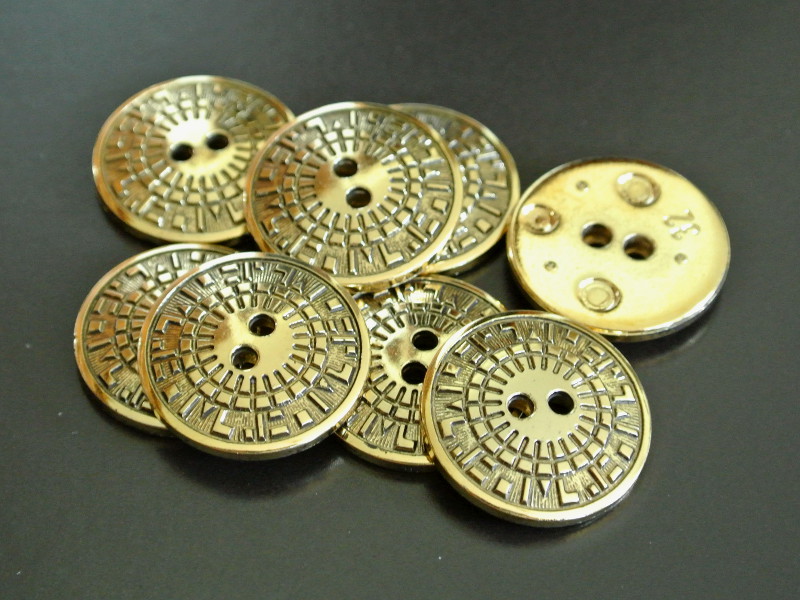 Altgoldfarbene Kunststoffknöpfe mit grafischem Design
