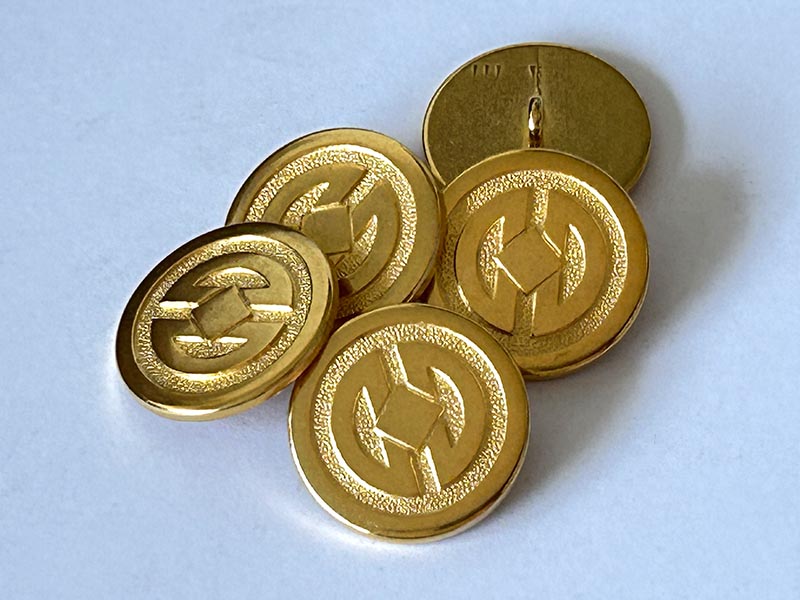 Edler Metallknopf in Gold matt und glänzend mit geometrischem Muster
