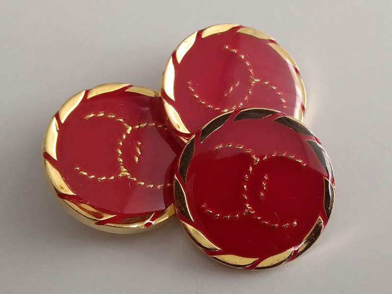 Interesante rot-goldene Kunststoffknöpfe mit Öse, sehr leicht