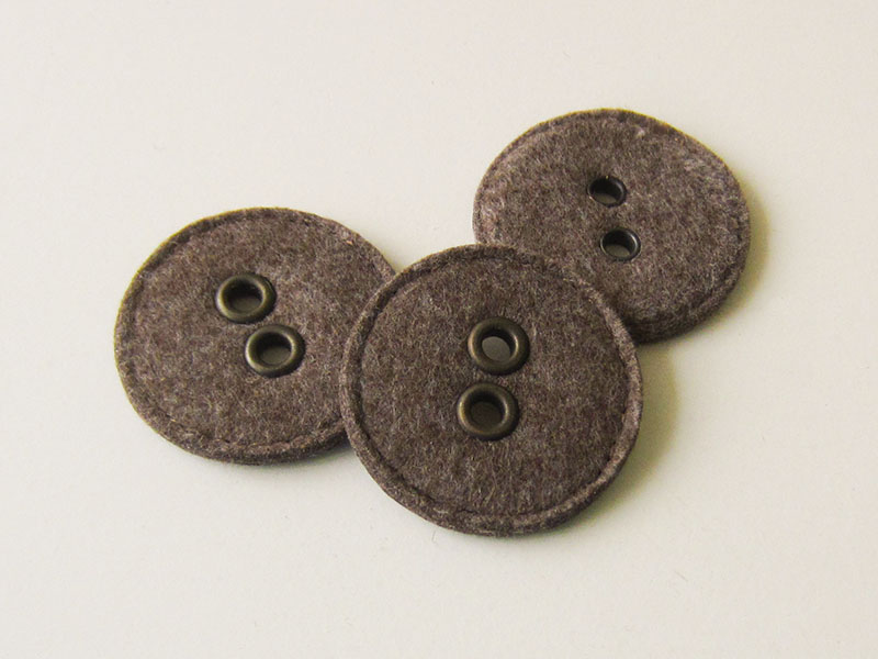 Origineller großer brauner Filz Knopf mit metallisch eingefassten Knopflöchern