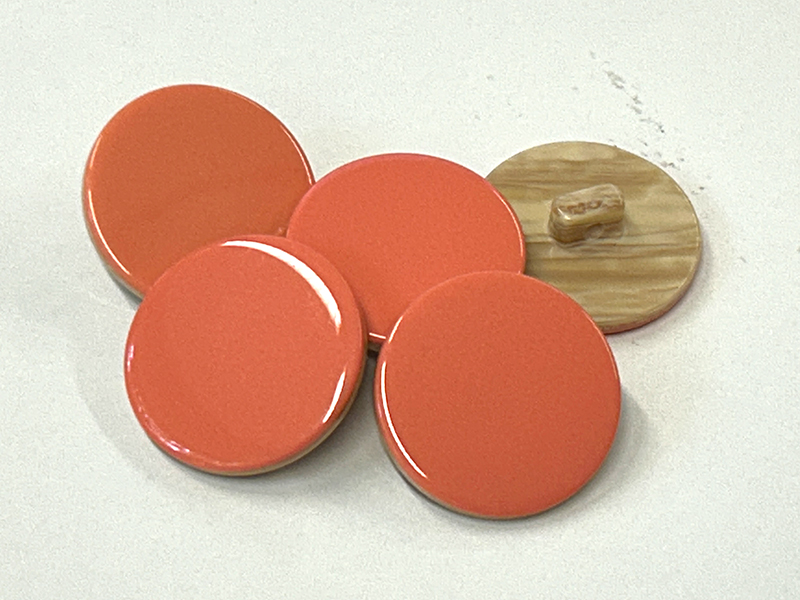 Pastellorange Ösenknöpfe aus Kunststoff mit dekorativer Rückseite
