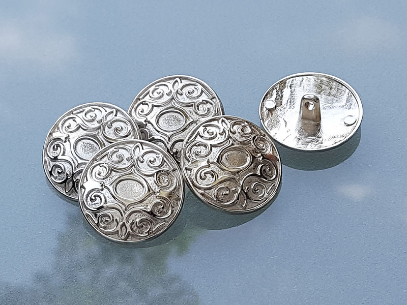 Silberfarbener Metallknopf mit elegantem Muster