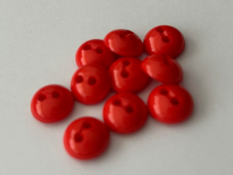 Kleine Blusenknöpfe in Orange mit halbkugelförmiger Form