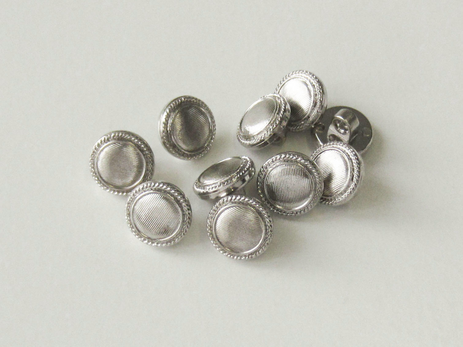 www.Knopfparadies.de - 2731si - Billige metallic silberfarbene Ösenknöpfe aus Kunststoff mit Fehlern