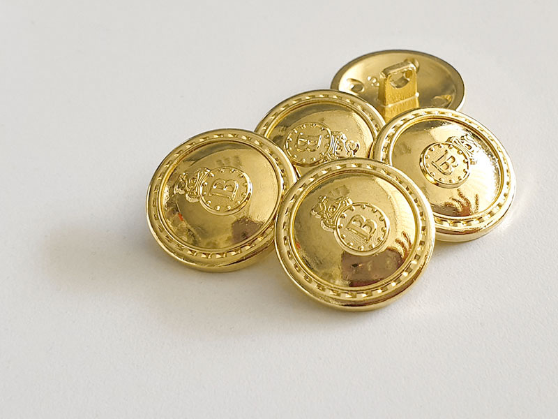 Besonders edle Metallknöpfe in glänzend Gold, leicht gewölbt mit großem "B"