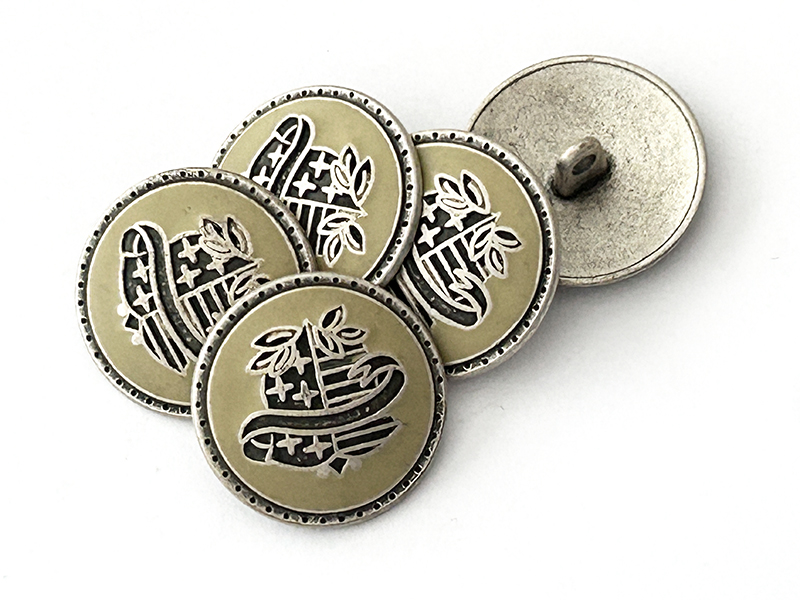 Metallknöpfe mit Wappenmotiv – Schwarz und Silber auf Grau-Beige