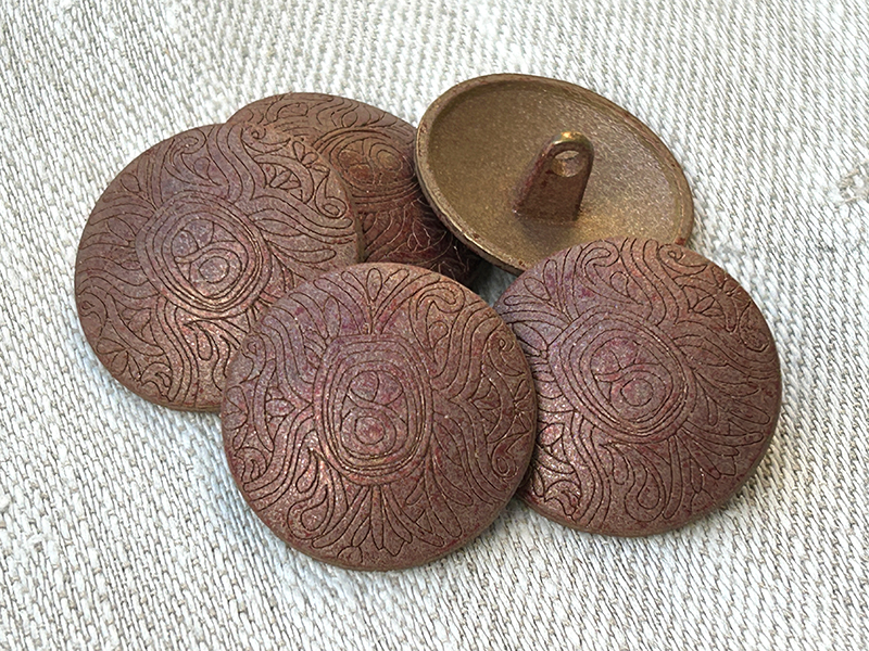 Kupferfarbene Metallknöpfe mit antik wirkender Ornamentzeichnung