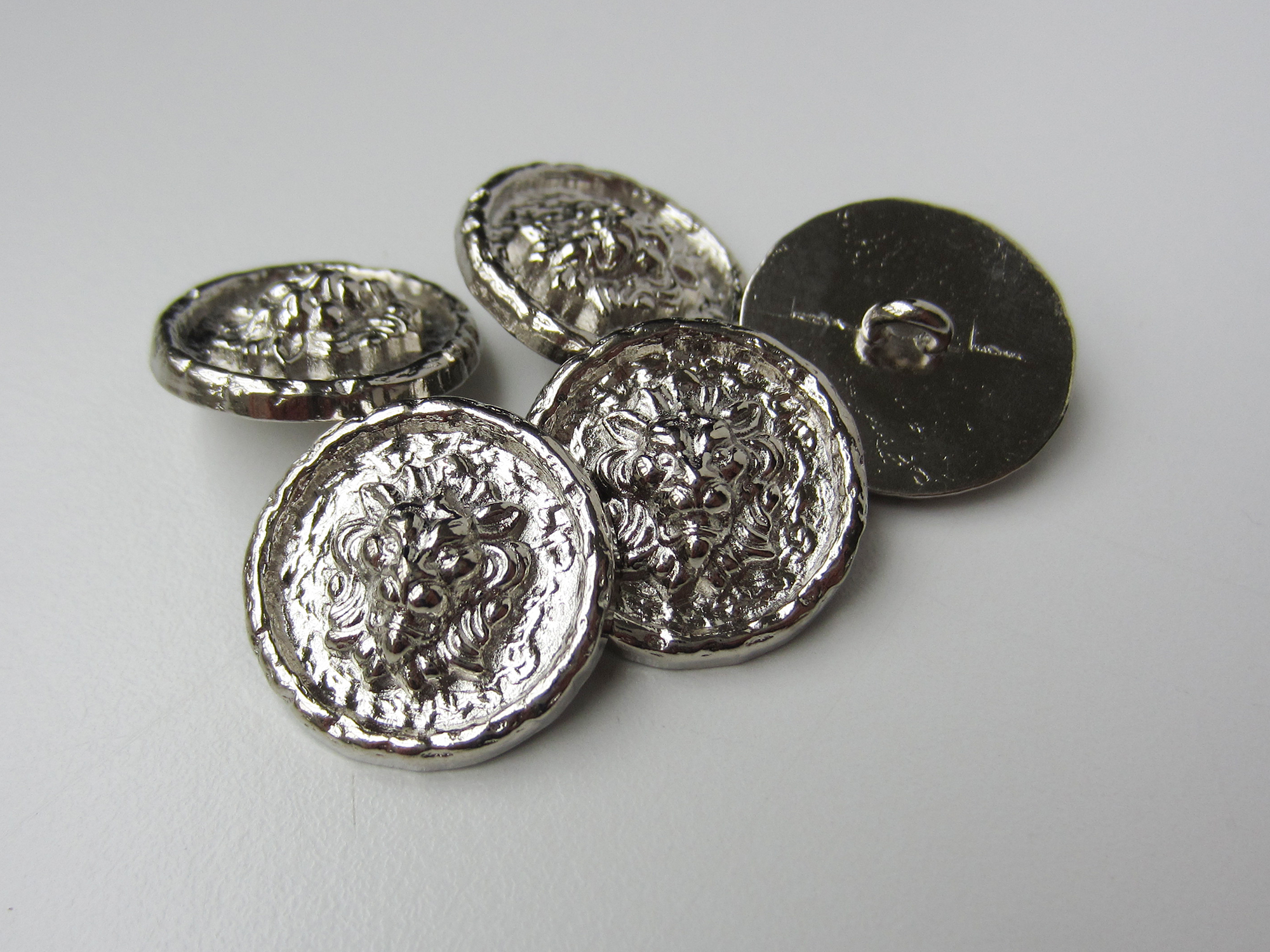 Glänzend silberfarbene Metallknöpfe mit Löwenkopf