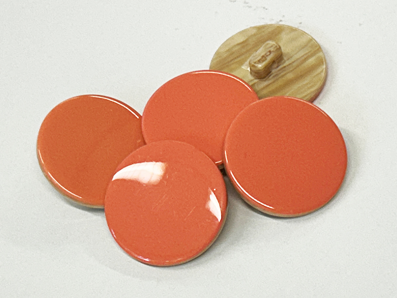 Pastellorange Ösenknöpfe aus Kunststoff mit dekorativer Rückseite