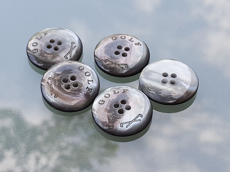 Grauer Vierloch Knopf in Perlmutt Optik mit Golf Motiv