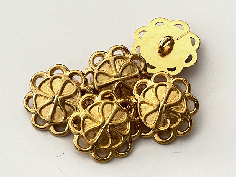 Filigraner goldfarbener Metallknopf mit durchbrochenem Rand