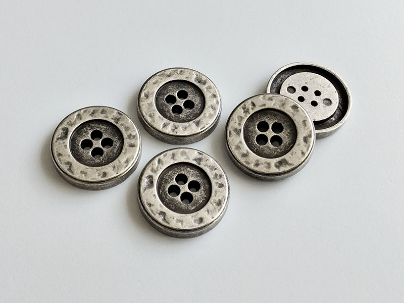 Altsilberfarbene, dicke Metallknöpfe in Vintage-Optik mit vier Knopflöchern