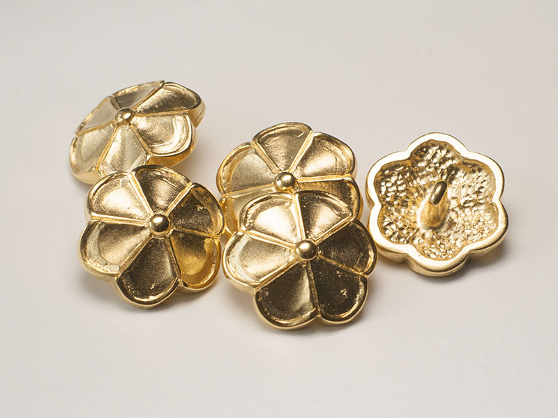 Goldfarbener Metall Ösen Knopf wie eine Blüte