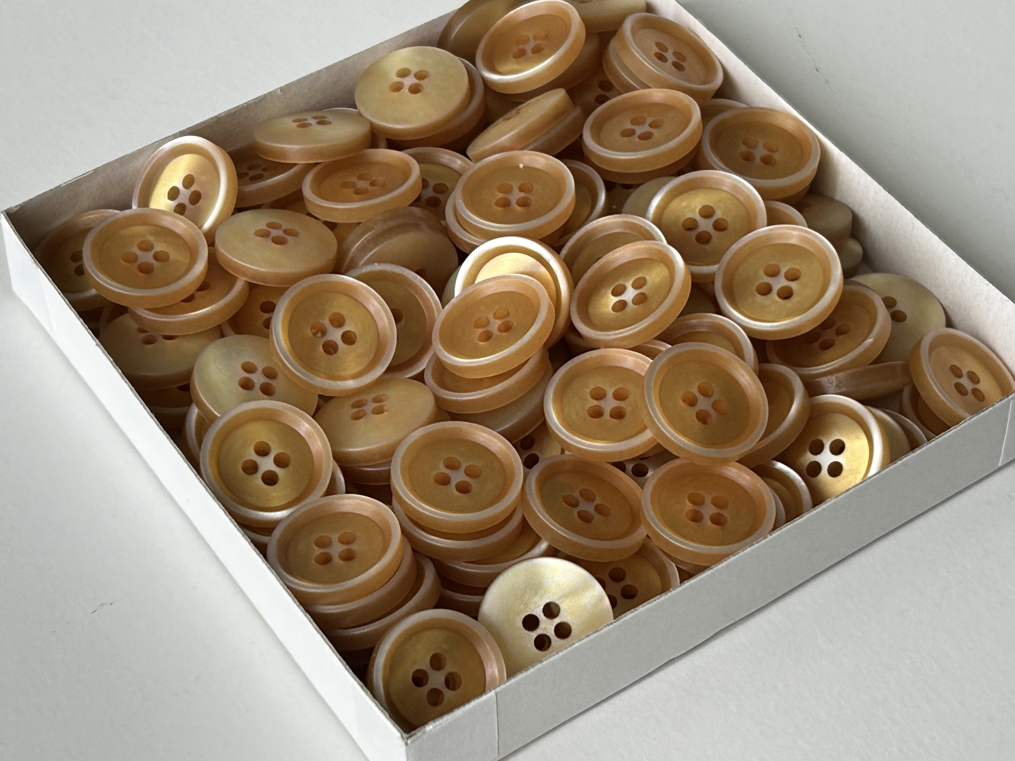 Attraktive beige- bis goldfarbene 4-Loch Knöfe zum Großhandelspreis